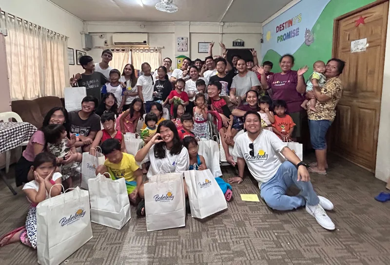 Bednbody team members with children and gift bags at a community day