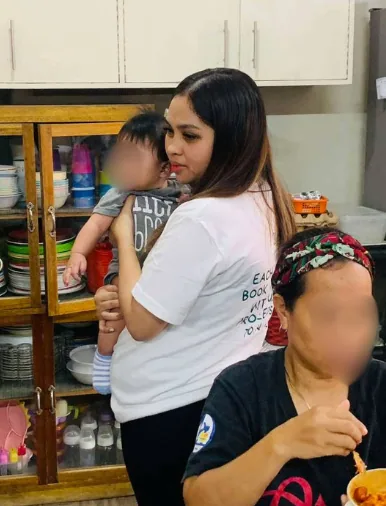 A Bednbody team member holding a child during a community visit