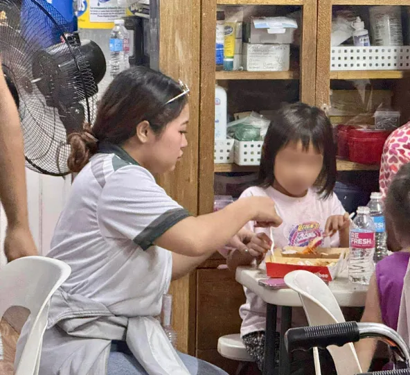 A Bednbody team member serving food to a child